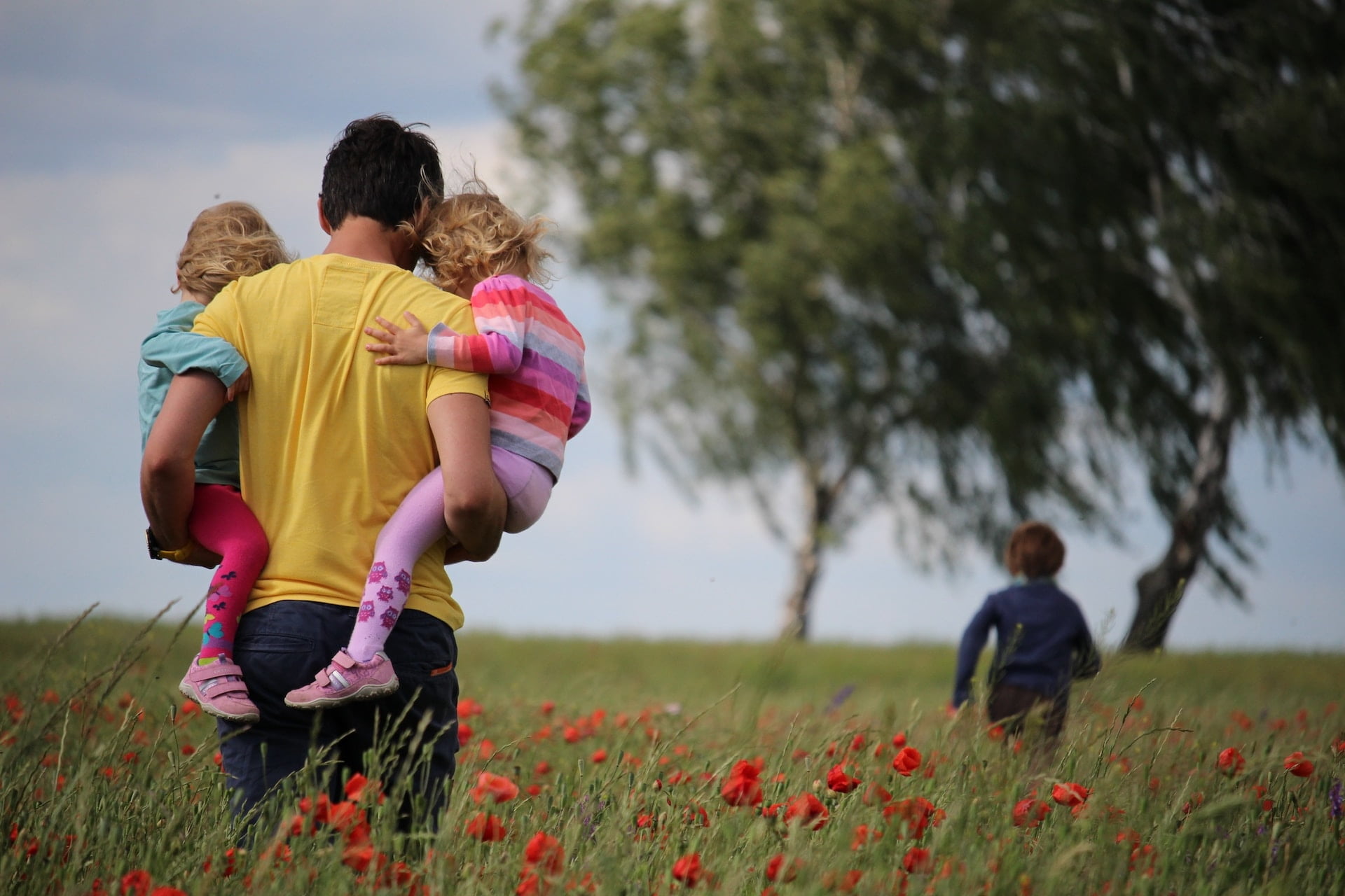 father, chasing child through field, 3 children, overwhelmed