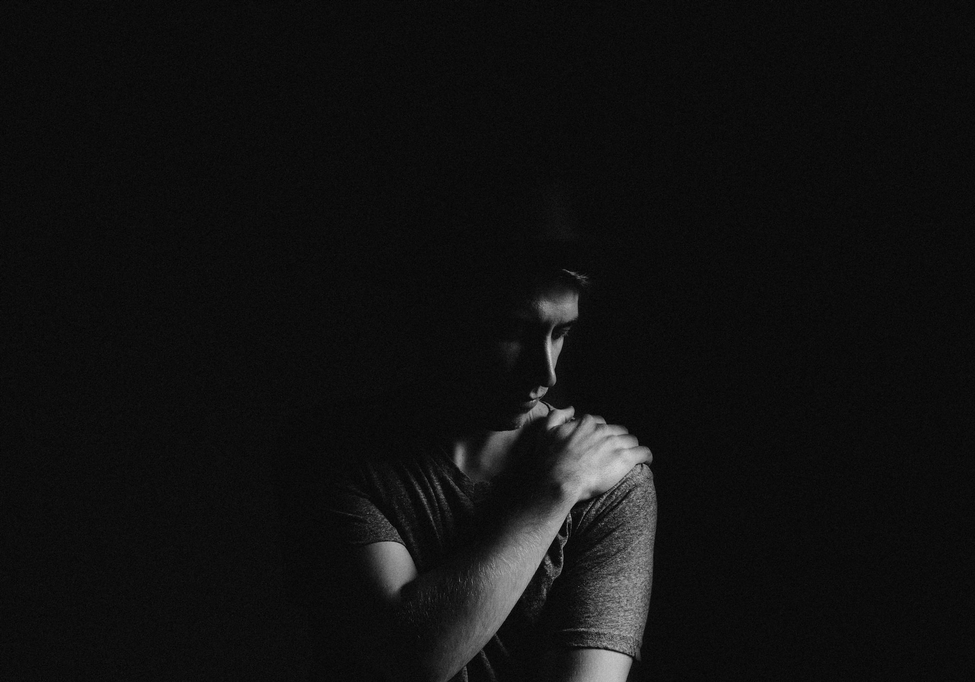 signs of male postpartum depression, man in dark room