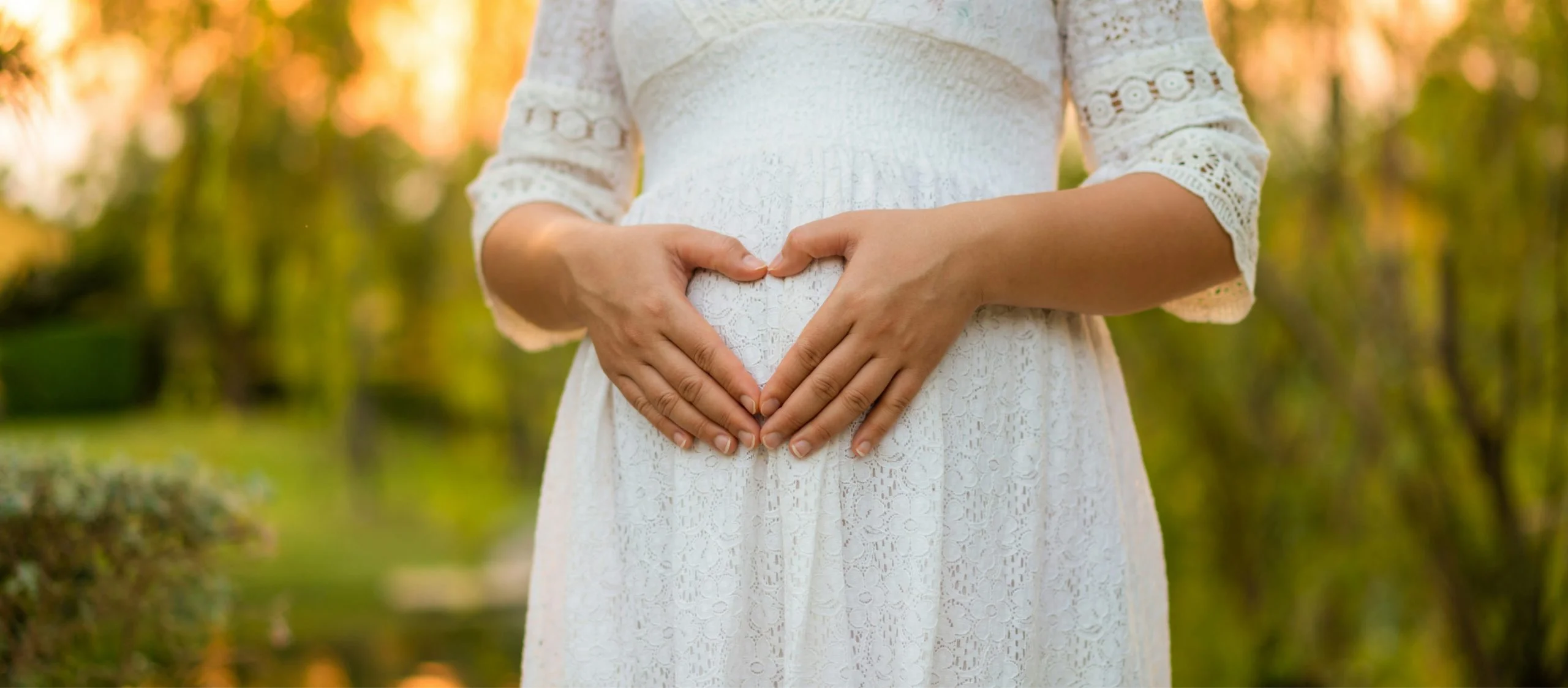 woman cupping hands in heart shape, hopeful for pregnancy
