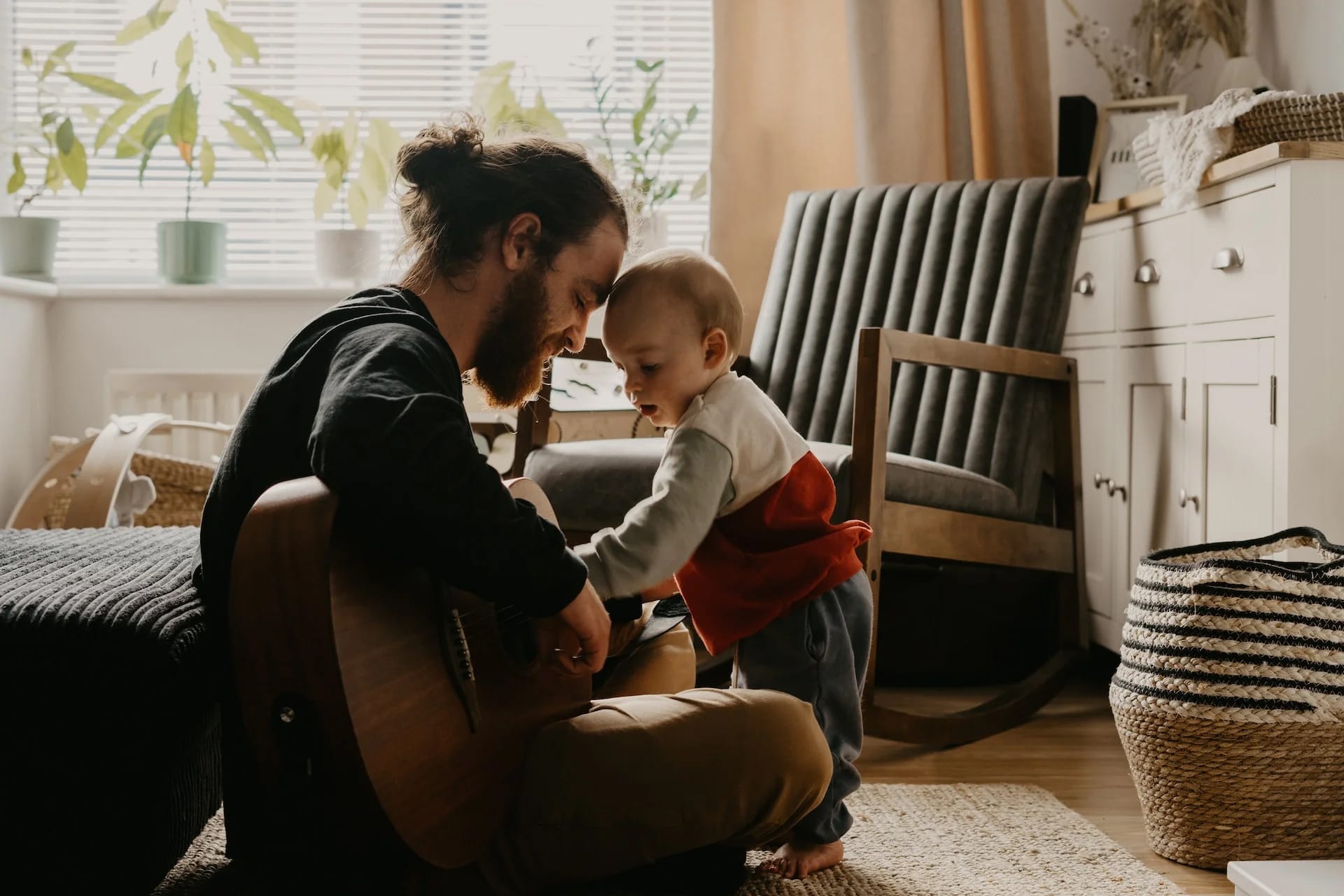 father playing guitar to baby, baby bonding